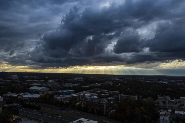 Sunbeams shine through dark, ominous storm clouds over midtown Atlanta