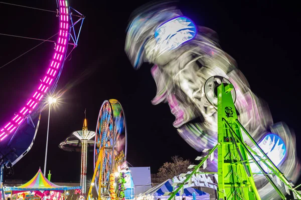 Mehrere Bunte Karnevalsfahrgeschäfte Verschwimmen Vor Nachthimmel — Stockfoto