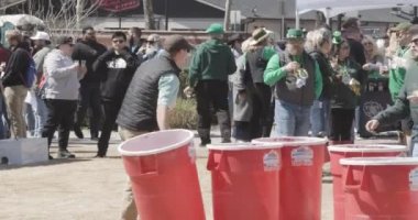 Suwanee, GA / USA - 18 Mart 2023: Genç bir adam Suwanee Bira Festivali 'nde, 18 Mart 2023' te, Suwanee, GA 'da, yaşam boyu bira pong oyununda, çöp kutusuna top attı..
