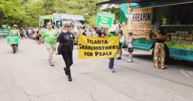 Atlanta, GA / USA 29 Nisan 2023: Atlanta 'da Barış İçin Babaanneler pankartı taşıyan kadınları 29 Nisan 2023' te Atlanta 'da düzenlenen Inman Park Festivali' nde kadınlar değil, Tüzük Silahları yazan insanlar izliyor.. 