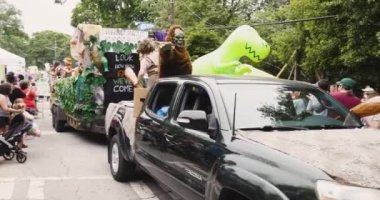 Atlanta, GA / USA 29 Nisan 2023: Bir kamyon tarafından çekilen bir mağara adamı temalı bir grup, 29 Nisan 2023 tarihinde Atlanta, GA 'da düzenlenen Inman Park Festivali' nde mağara adamı kostümleriyle yürüyen insanlar tarafından takip ediliyor.. 