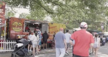 Atlanta, GA / USA 29 Nisan 2023: İnsanlar 29 Nisan 2023 'te Atlanta, GA' da Inman Park Festivali 'nde bir caddeye dizilmiş yemek kamyonlarını ziyaret ediyor. 