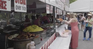 Atlanta, GA / ABD 29 Nisan 2023: 29 Nisan 2023 'te Atlanta, GA' da Inman Park Festivali 'nde insanlar yiyecek alırken büyük tabak ızgara tavuk, pirinç ve sosis sergileniyor. 