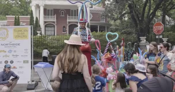 美国亚特兰大 2023年4月29日 在美国亚特兰大举行的英曼公园节上 一名男子举着高跷为孩子们做气球玩具 — 图库视频影像