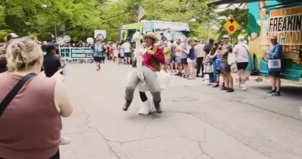 2023年4月29日米国アトランタ 2023年4月29日にアトランタで開催されるインマン パーク フェスティバルのパレードに参加しながら 男がダチョウに乗っている様子がコミカルに描かれている — ストック動画