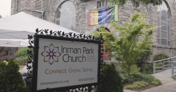アトランタ Usa 2023年4月29日 2023年4月29日にアトランタで開催されるインマン パーク フェスティバルで あなたを愛読しているインマン パーク教会の建物からLgbtqの虹のバナーが掛けられています — ストック動画