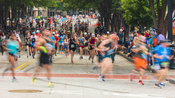 Atlanta, GA / USA - July 4, 2023:  Telephoto shot shows thousands of runners packing Peachtree Street at the annual Peachtree Road Race on July 4, 2023 in Atlanta, GA.