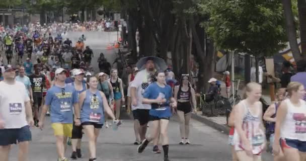 アトランタ アメリカ 2023年7月4日 アトランタの2023年7月4日に毎年恒例のピーチツリーロードレースで歩いている間 男は傘の帽子をかぶります — ストック動画