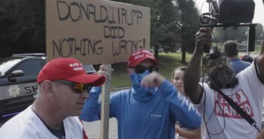 Atlanta, GA / ABD 24 Ağustos 2023: Bir grup Trump taraftarı, 24 Ağustos 2023 'te Atlanta, GA' da bulunan Fulton County hapishanesinde Donald Trump 'ın tutuklanmasını beklerken elinde Trump karşıtı işaretler tutan bir kadın protestocunun etrafını sardı.. 