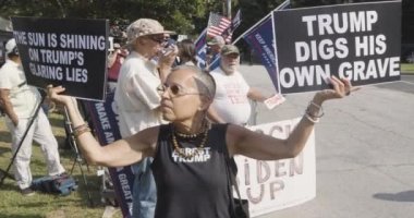 Atlanta, GA / ABD 24 Ağustos 2023: Bir kadın, 24 Ağustos 2023 'te Atlanta, GA' da Donald Trumps 'ın tutuklanması beklentisiyle Fulton County hapishanesinin önünde toplanan Trump karşıtı destekçiler arasında pankartlar astı.. 