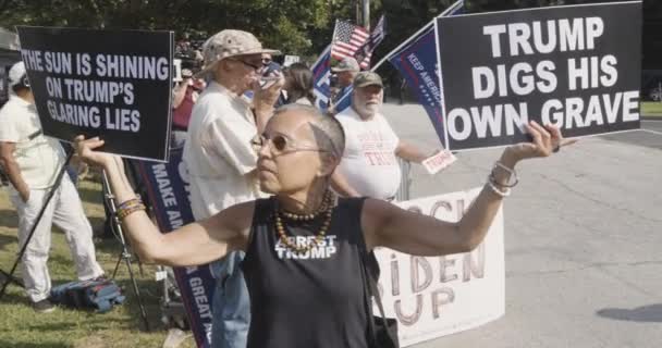 2023年8月24日 美国亚特兰大 2023年8月24日 当人们聚集在富尔顿县监狱外等待唐纳德 特朗普被捕时 一位女性在支持特朗普的人群中高举反特朗普的标语 — 图库视频影像