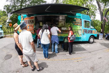 Atlanta, GA / ABD - 29 Nisan 2023: Fisheye lensleri, 29 Nisan 2023 'te Atlanta, GA' da düzenlenen Inman Park Festivali 'nde insanların yemek kamyonunda kuyrukta beklediklerini gösteriyor..