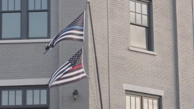 Birinde mavi çizgili, diğerinde kırmızı çizgili iki Amerikan bayrağı var. İtfaiyecilere ve kolluk kuvvetlerine destek oluyor. Georgia 'da bir apartmanın balkonunda uçuyorlar.. 