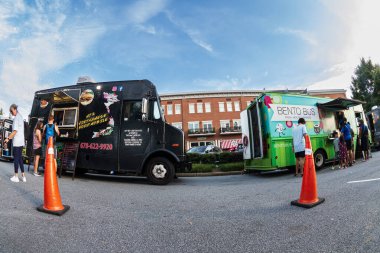 Suwanee, GA / USA - 4 Ağustos 2023: Düşük açılı balık gözü çekimi, 4 Ağustos 2023 Cuma günü Suwanee, GA 'da yemek kamyonu siparişi vermek için sırada bekleyen insanları gösteriyor..