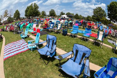 Suwanee, GA / USA - August 12, 2023:  Dozens of empty lawn chairs are set up for an outdoor summer concert at the Suwanee Town Park amphitheater, on August 12, 2023 in Suwanee, GA. clipart