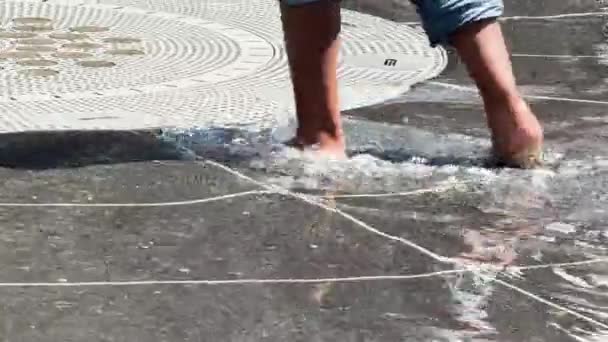 服装展示的是身份不明的孩子们的脚 他们卷起裤腿 在喷泉中散步和泼水 — 图库视频影像