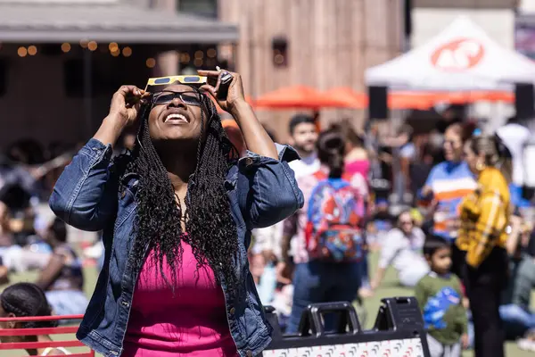 アトランタ Usa 2024年4月8日 女性はアトランタの2024年4月8日の時計パーティーで太陽食全体を見るために特別なメガネを使用します ストック画像