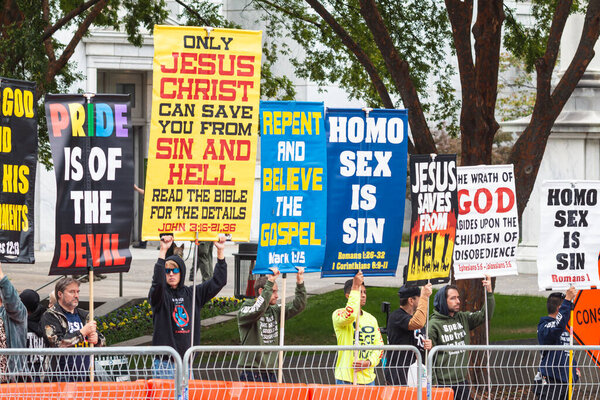 Atlanta, GA / USA - October 15, 2023:  Anti-gay, right-wing activists display homophobic signs as they await the pride parade to pass by on October 15, 2023 in Atlanta, GA.