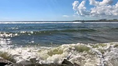 Yavaş çekim, okyanus dalgalarının iskeledeki kayalara çarptığını ve Lauderdale 'deki kamera lenslerine çarptığını gösteriyor.. 