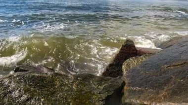 Yavaş çekim, okyanus dalgalarının iskeledeki kayalara çarptığını ve Lauderdale 'deki kamera lenslerine çarptığını gösteriyor.. 