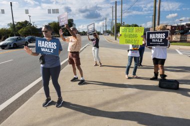 Lawrenceville, GA / USA - 5 Eylül 2024: Aktivistler, Kamala Harris 'in 5 Eylül 2024' te Lawrenceville, GA 'da bulunan yoğun bir sokak köşesinde yerel bir Honk etkinliğinde Kamala Harris' i tanıtan kampanya panolarına sahipler..