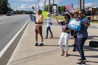 Lawrenceville, GA / USA - 5 Eylül 2024: İnsanlar 5 Eylül 2024 'te Lawrenceville, GA' da bulunan kalabalık bir sokak köşesinde, Harris için yerel bir Honk etkinliğinde Kamala Harris 'i tanıtan kampanya panolarına sahipler..