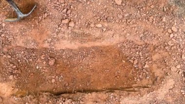 Bir kürek, yeni kazılmış küçük, sığ bir mezarın yanındaki toprak yığınına sıkıştı.. 