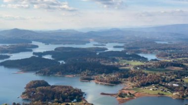 Zaman çizelgesi, bulutların ve gölgelerin yüksek irtifa perspektifinin Appalachian dağ manzarasında bir gölün üzerinde hareket ettiğini gösteriyor..