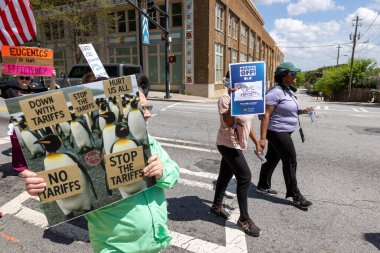 Atlanta, GA / ABD - 5 Nisan 2025: 5 Nisan 2025 'te Atlanta, GA' da penguenlerin Hands Off March 'ta gümrük vergilerini protesto ettiğini gösteren tabela tutan adam.