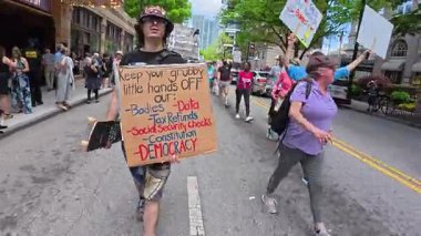 Atlanta, GA / ABD 5 Nisan 2025: 5 Nisan 2025 'te Atlanta, GA' da Hands Off protesto etkinliğinde yürürken GOP ajandası taşıyan bir adamın görüntüsü. 