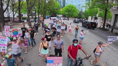 Atlanta, GA / USA 5 Nisan 2025: Yükseltilmiş izleme görüntüleri, 5 Nisan 2025 'te Atlanta, GA' da düzenlenen protestoda binlerce insanın el ilanı tuttuğunu ve kameranın önünden geçtiğini gösteriyor.. 