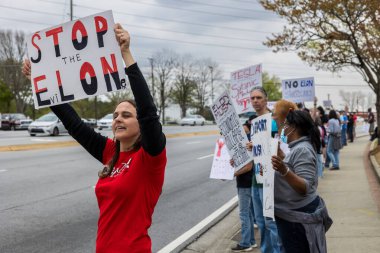 Duluth, GA / USA - 29 Mart 2025: Duluth, GA 'da düzenlenen Tela protesto etkinliğinde kadın anti-Elon Musk işareti sergiliyor.