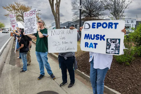 Duluth, GA / USA - 29 Mart 2025: Protestocular 29 Mart 2025 'te Duluth, GA' da düzenlenen bir Tesla protestosunda Elon Musk karşıtı tabelalar sergiliyorlar.