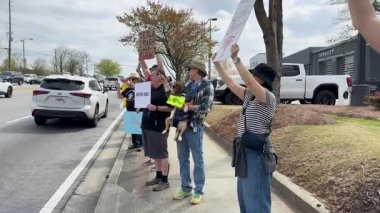 Duluth, GA / USA 29 Mart 2025: 29 Mart 2025 'te Duluth, GA' da düzenlenen bir Takedown protestosunda Teslas 'ınızı Kırpın yazan bir tabela takmış bir köpek taşıyıcısı taşıyan bir adam.. 