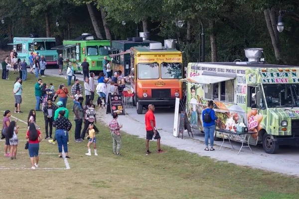 Lilburn, GA / USA - 10 Ekim 2023: İnsanlar 10 Ekim 2023 'te Lilburn, GA' da bir kamu parkında beş yemek kamyonunda kuyruğa girdiler..