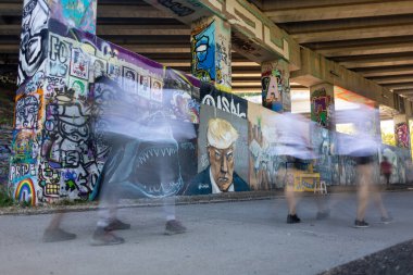Atlanta, GA / USA - 23 Eylül 2023: İnsanlar 23 Eylül 2023 'te Atlanta Beltline boyunca bir duvara Trump' ın sabıka fotoğrafı çizerken hareket bulanıklığı yaşıyorlar..