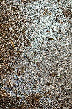 Bulanık, kirli sel suyunun dikey yakın çekimi dokulu bir arkaplan oluşturur