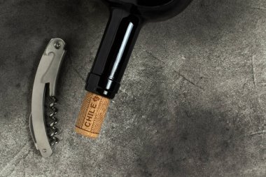 Şili şarabı. Siyah arka planda şişe, tirbuşon ve mantar..