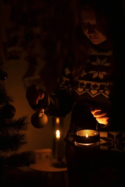 乌克兰 2022年冬季 一个女人在黑暗中用蜡烛装饰圣诞树 — 图库照片
