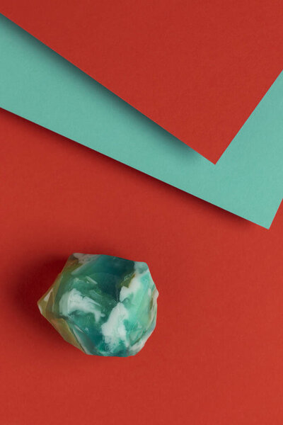Turquoise handmade soap on red and blue background. Top view.