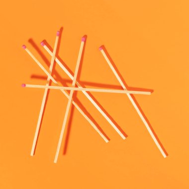Matches on orange background. Top view.