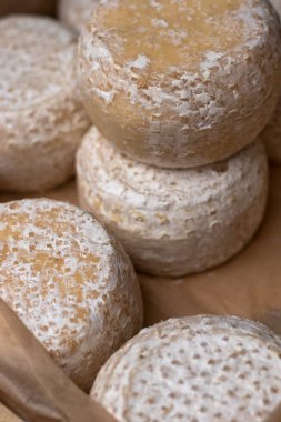 Yıllanmış peynir. Pazardaki bir kutuda yuvarlak peynir parçaları..