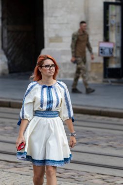 Lviv, Ukrayna - 24 Ağustos 2023. Ukrayna 'nın Bağımsızlık Günü. Nakışlı elbiseli genç bir kadın şehirde yürüyor..