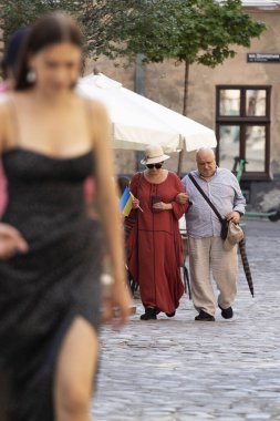 Lviv, Ukrayna - 24 Ağustos 2023. Ukrayna 'nın Bağımsızlık Günü. Elinde Ukrayna bayrağı olan bir çift kıdemli insan şehirde yürüyor..
