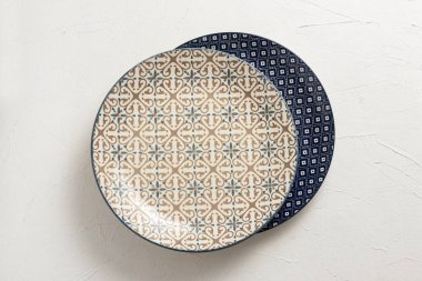 Beyaz zemin üzerinde boş porselen plakalar.