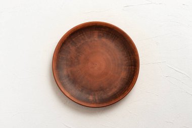 Beyaz arkaplanda boş bir kil plaka.