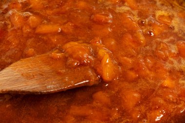 Tahta kaşık ve taze kayısı reçeli. Yakın plan..