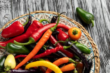 Tabakta acı kırmızı biber, jalapeno ve buena mulata biberi karışımı. Yakın çekim, üst görünüm.