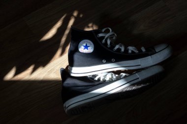 Lviv, Ukrayna - 18 Ağustos 2024. Bir çift siyah beyaz Chuck Taylor All Star Converse yerde yatıyor.