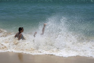 TARIFA, İspanya - 17 Haziran 2023: Çocuklar 17 Haziran 2023 tarihinde İspanya 'nın Tarifa kentindeki Gibraltar Boğazı Valdevaqueros plajında dalgaların tadını çıkarıyorlar.